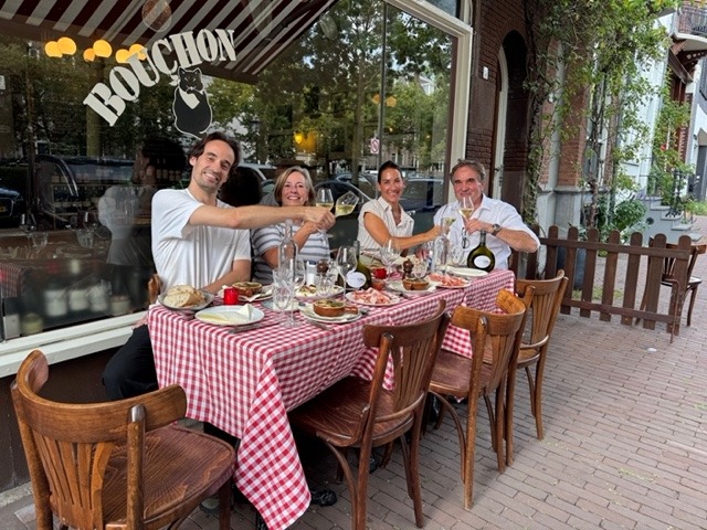 Gasten proosten met wijn op het terras van Tire-Bouchon